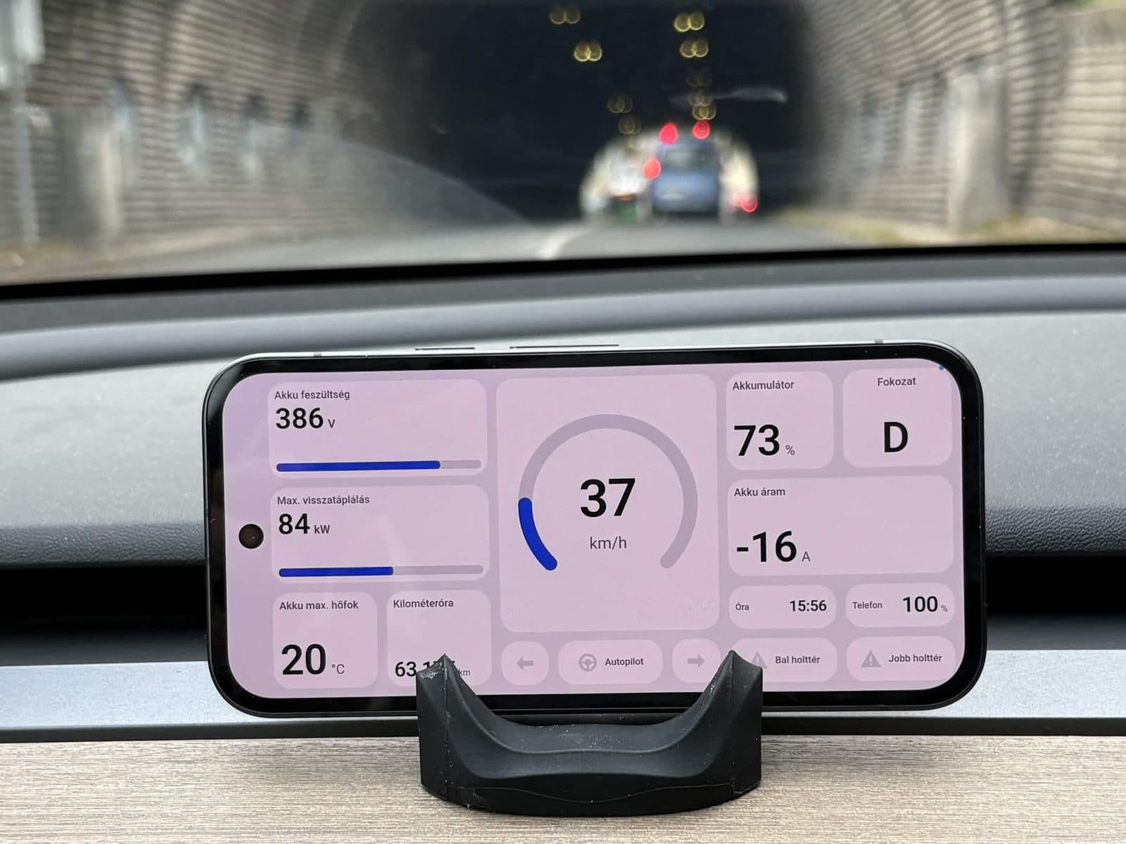 DashPilot in its light theme on a Tesla dashboard, showing pack voltage, regen limit, battery current and speed while driving into a tunnel
